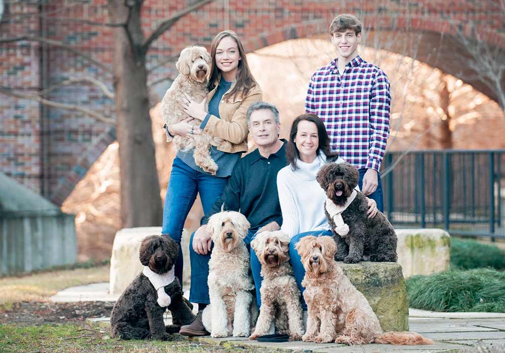 Australian labradoodle breeder family posing with six Australian labradoodles